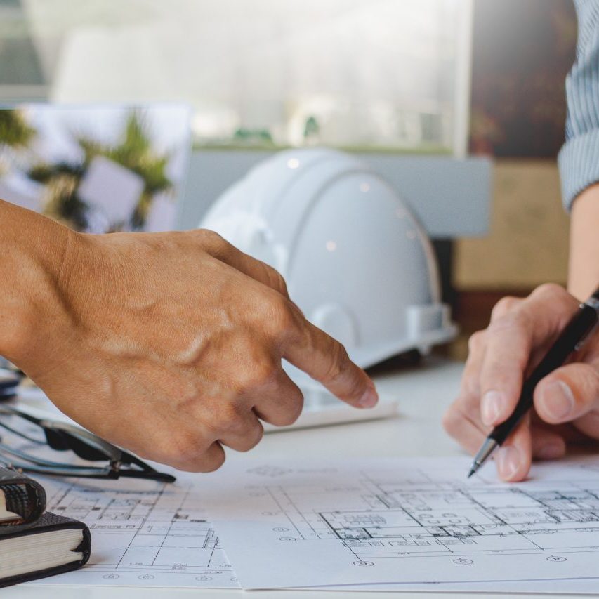 Cooperation Corporate designers in the office are working on a new project Planning blueprint Design at construction site at desk in office