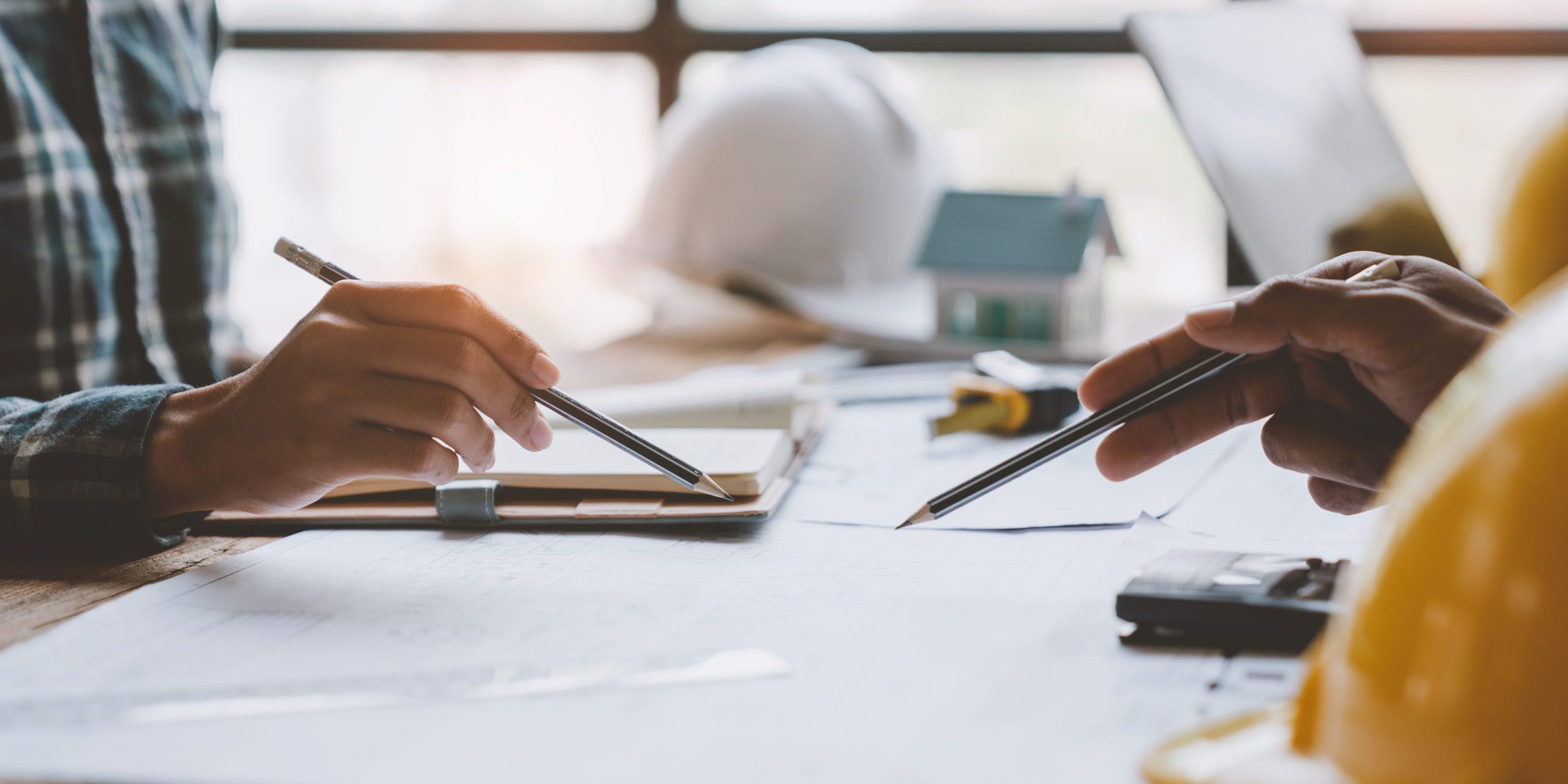 Construction concept of meeting engineers or architects for projects working with partners and engineering tools on modeling and blueprint design in office.